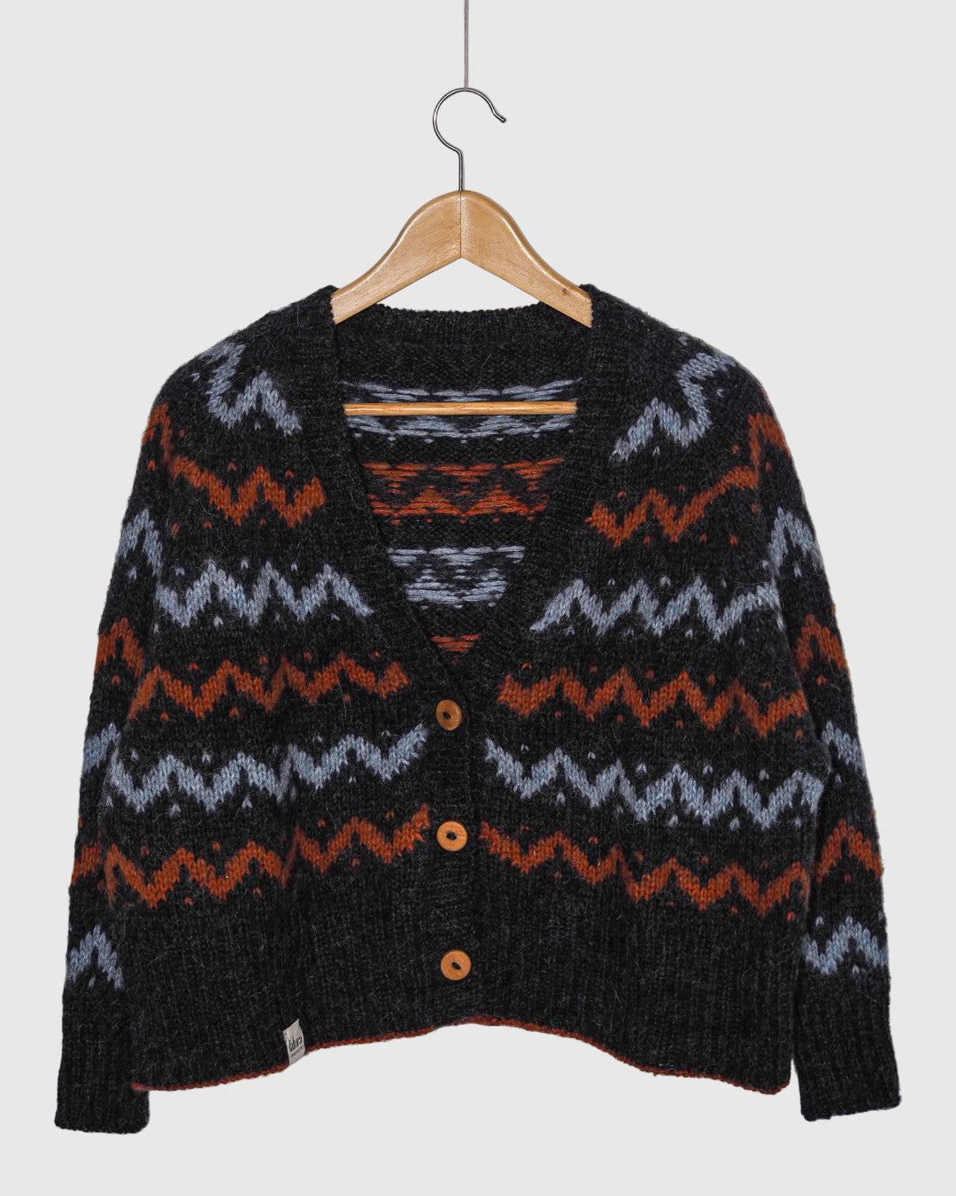 Cárdigan de punto Lalura Design con patrón geométrico en zigzag, tonos gris, azul y naranja, y botones de madera.