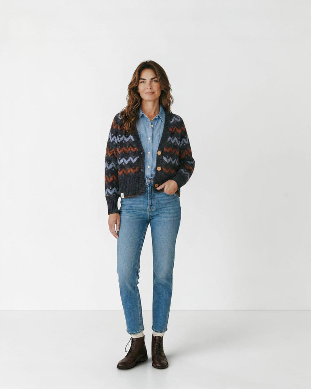 Mujer vistiendo cárdigan Lalura Design de punto grueso con patrón geométrico en zigzag gris, azul y naranja
